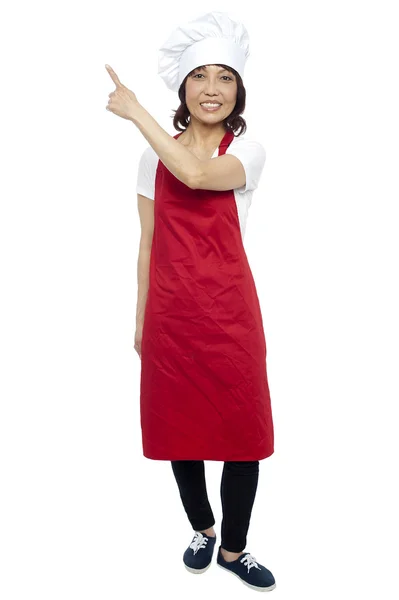 Beautiful female chef pointing at the copy space — Stock Photo, Image