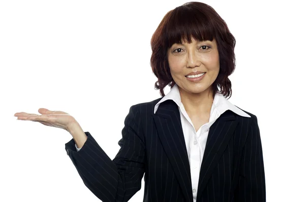 Lächelnde asiatische Frau präsentiert Kopierraum — Stockfoto