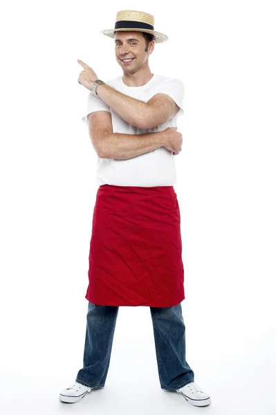 Man wearing a hat and apron pointing away — Stock Photo, Image