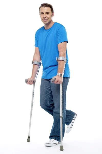 Young man with crutches trying to walk — Stock Photo, Image