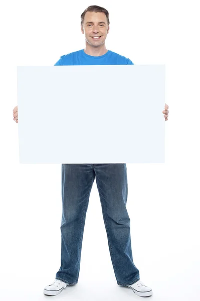 Guapo casual chico sosteniendo en blanco anuncio tablero — Foto de Stock