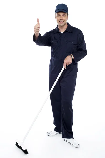 Cleaning guy holding broom and showing thumbs up — Stock Photo, Image