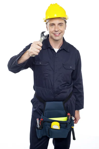 Lächelnder Reparateur hält Schraubenzieher hoch — Stockfoto