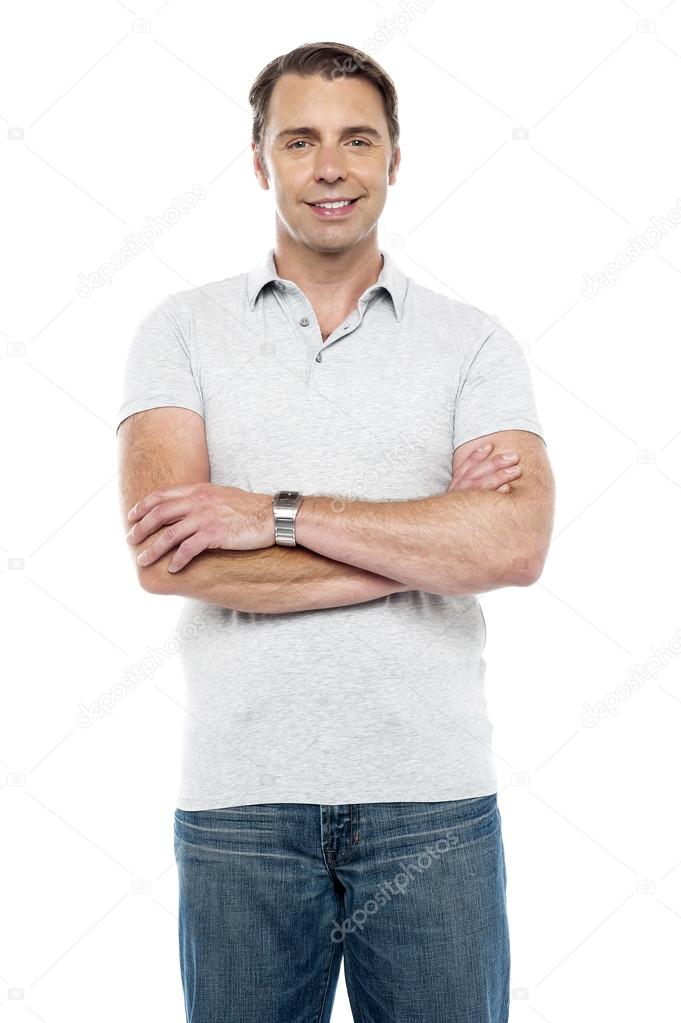 Joyous young man posing with his arms crossed
