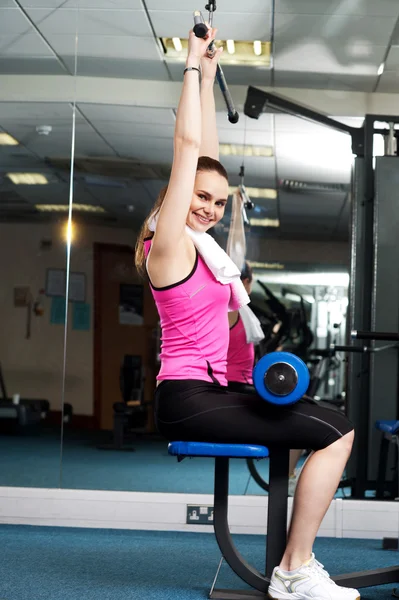 Donna tonificare i muscoli superiori e centrali in multi palestra — Foto Stock