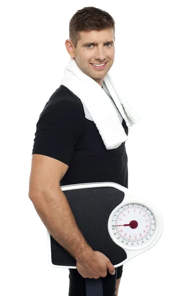 Healthy young man with a weight scale — Stock Photo, Image