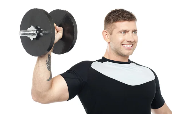 Musculoso macho mostrando sus bíceps levantando pesada mancuerna —  Fotos de Stock