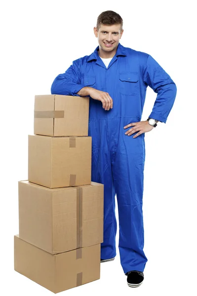 Relocation staff member resting against stack of cartons — Stock Photo, Image