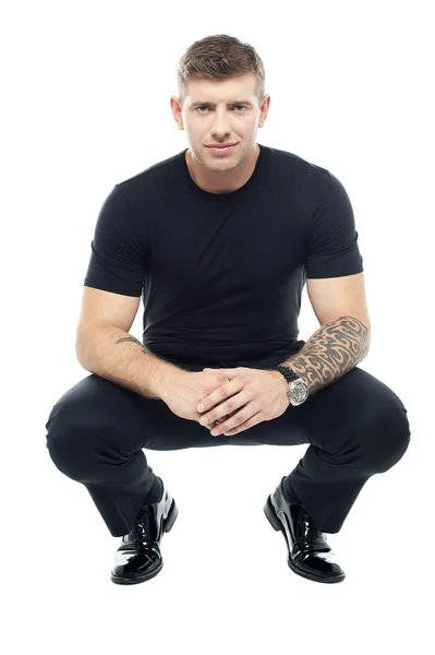 Handsome male bouncer squatting position — Stock Photo, Image