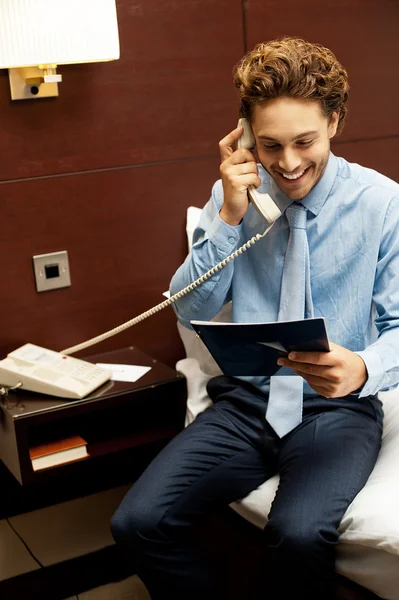 Un gentleman souriant passe une commande au téléphone — Photo