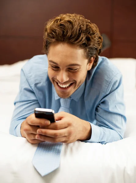 Cheerful man enjoying reading funny messages — Stock Photo, Image