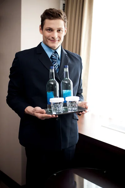 Mordomo masculino segurando bebidas frescas para os clientes — Fotografia de Stock