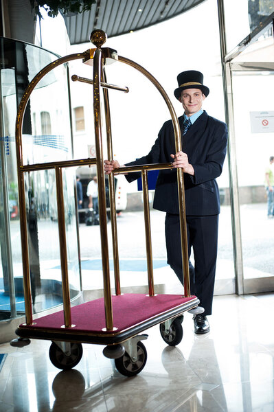 Profile shot of a doorman holding a cart
