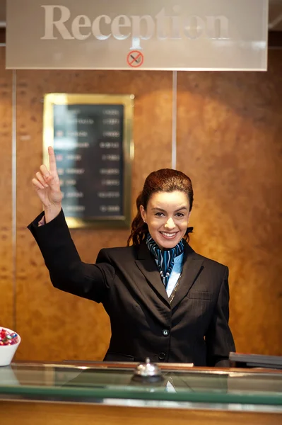 Bella receptionist femminile che indica verso l'alto — Foto Stock