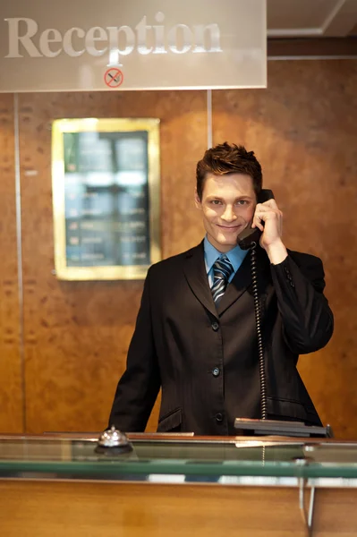 配置文件的一个英俊的接待员在电话上镜头 免版税图库图片