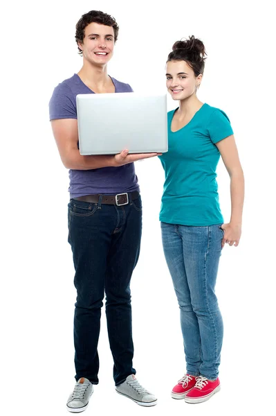 Teen friends holding laptop. Full length shot — Stock Photo, Image