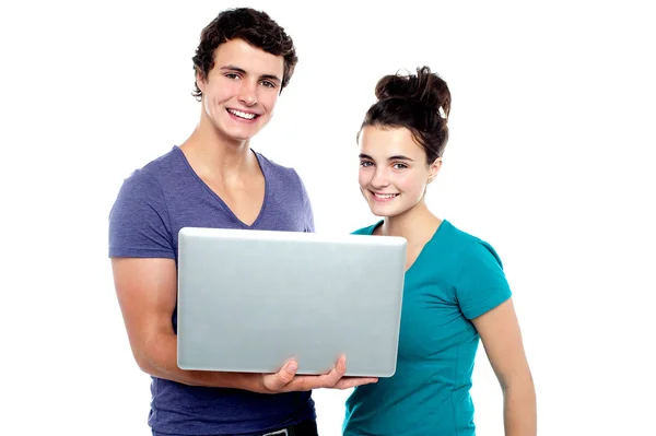 Charming teen couple holding a laptop — Stock Photo, Image