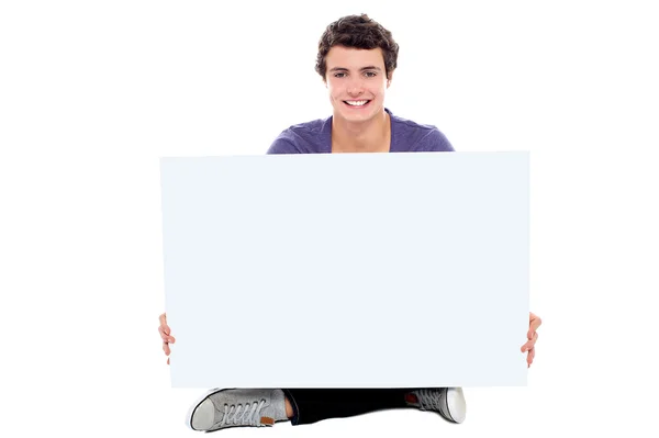 Teenager zeigt weiße Plakatwand vor Kamera — Stockfoto