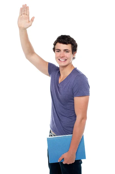 Yakışıklı genç bir adam sağ elini koyarak — Stok fotoğraf