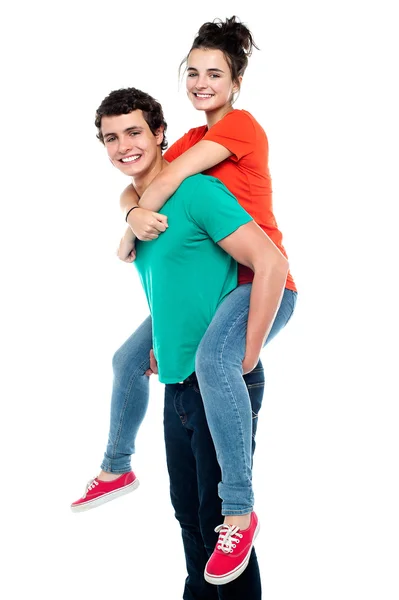 Handsome young man giving a piggyback ride to his girlfriend — Stock Photo, Image