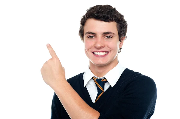 Menino bonito em uniforme indicando para cima — Fotografia de Stock