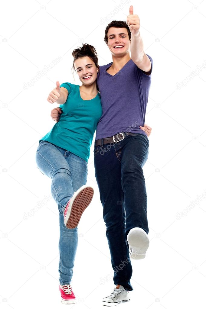 Teen love couple enjoying themselves, gesturing thumbs up