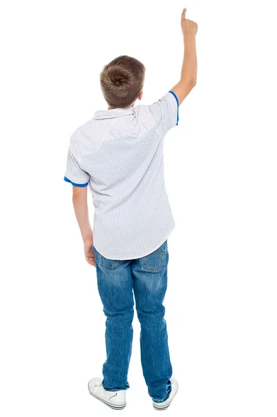 Rear view of a school boy pointing upwards — Stock Photo, Image