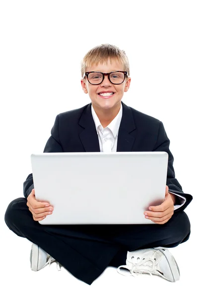 Bir dizüstü bilgisayar ile katta oturan neşeli genç çocuk — Stok fotoğraf