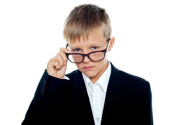 Schattige kleine zakelijke jongen op zoek via zijn bril — Stockfoto