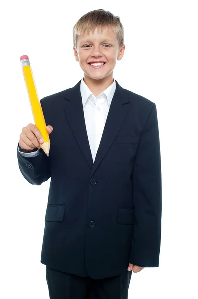 Joyeux jeune garçon tenant géant taille crayon jaune — Photo