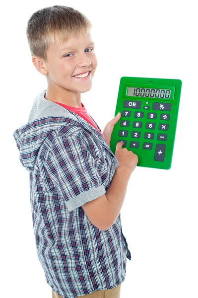 Hoş genç bir öğrenci büyük yeşil hesap makinesi kullanma — Stok fotoğraf
