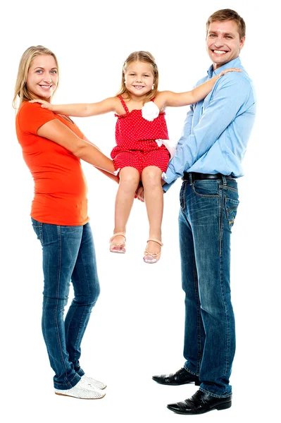Девочка сидит на вытянутых руках своих родителей — стоковое фото