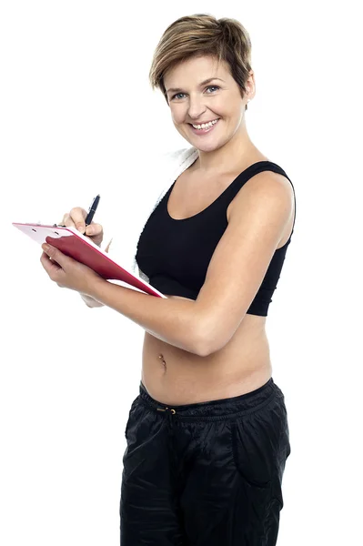 Istruttore di ginnastica femminile scrivere dieta grafico — Foto Stock