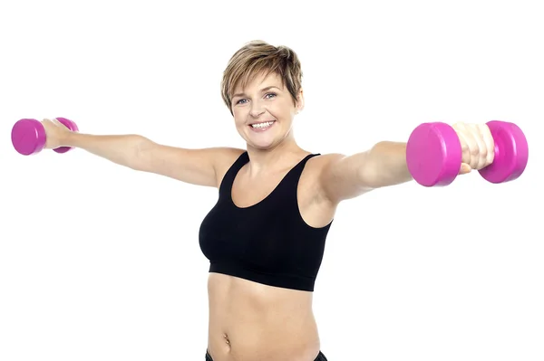 Mulher fitness exercitando-se com halteres rosa — Fotografia de Stock