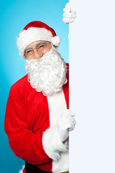 Santa poseren naast lang leeg reclamevaandel — Stockfoto