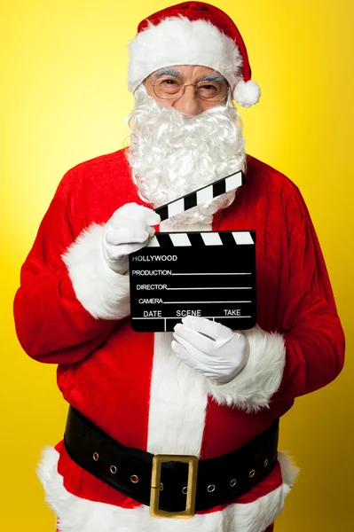 Alegre kris kringle posando com clapperboard — Fotografia de Stock