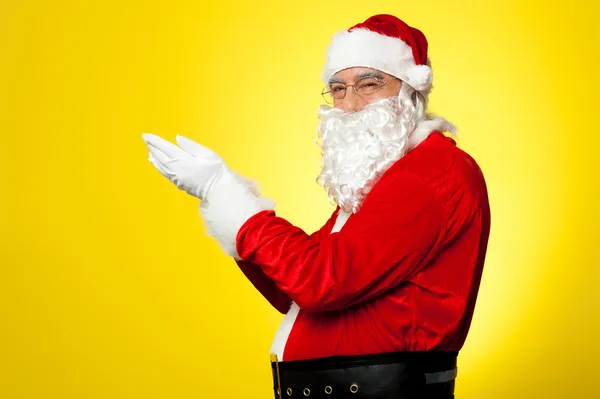 Noel Baba yan yana kameranın açık avuç içi ile yan profili — Stok fotoğraf