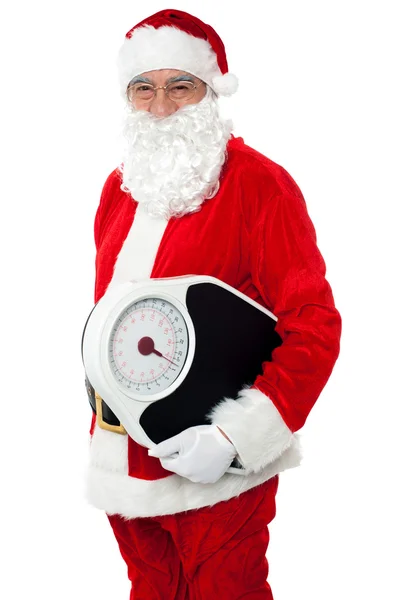 Aged male Santa holding weighing scale — Stock Photo, Image