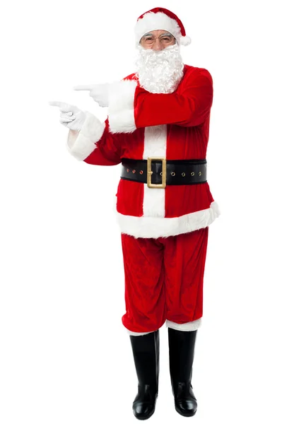 Man in Santa costume indicating at copy space area — Stock Photo, Image