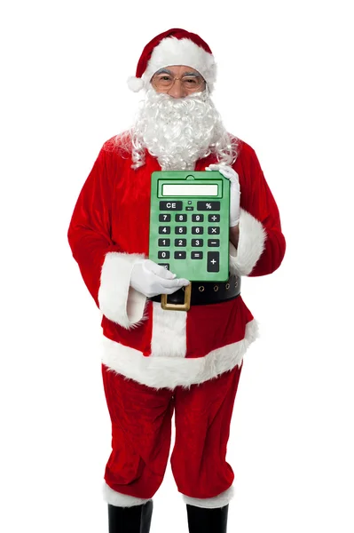 Velho vestido de Papai Noel mostrando uma grande calculadora verde — Fotografia de Stock