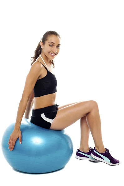 Mulher bonita relaxante em grande bola de exercício azul — Fotografia de Stock