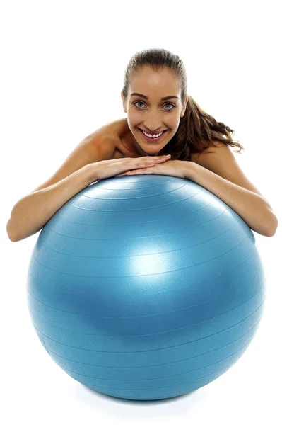 Женщина склоняется над большим голубым швейцарским мячом — стоковое фото