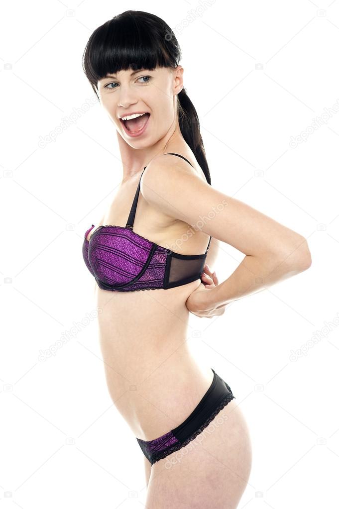 Ravishing woman unhooking her brassiere Stock Photo by