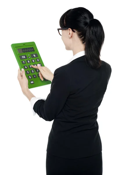 Visão traseira da mulher corporativa usando calculadora verde — Fotografia de Stock
