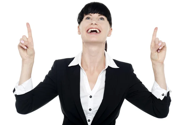 Excited businesswoman looking ad pointing upwards — Stock Photo, Image