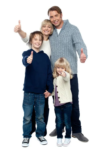Adorable family in winter clothes gesturing thumbs up — Stock Photo, Image