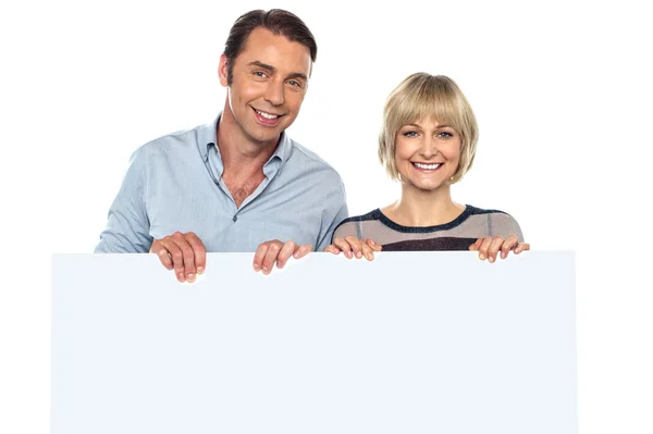 Lovely couple standing behind blank billboard — Stock Photo, Image