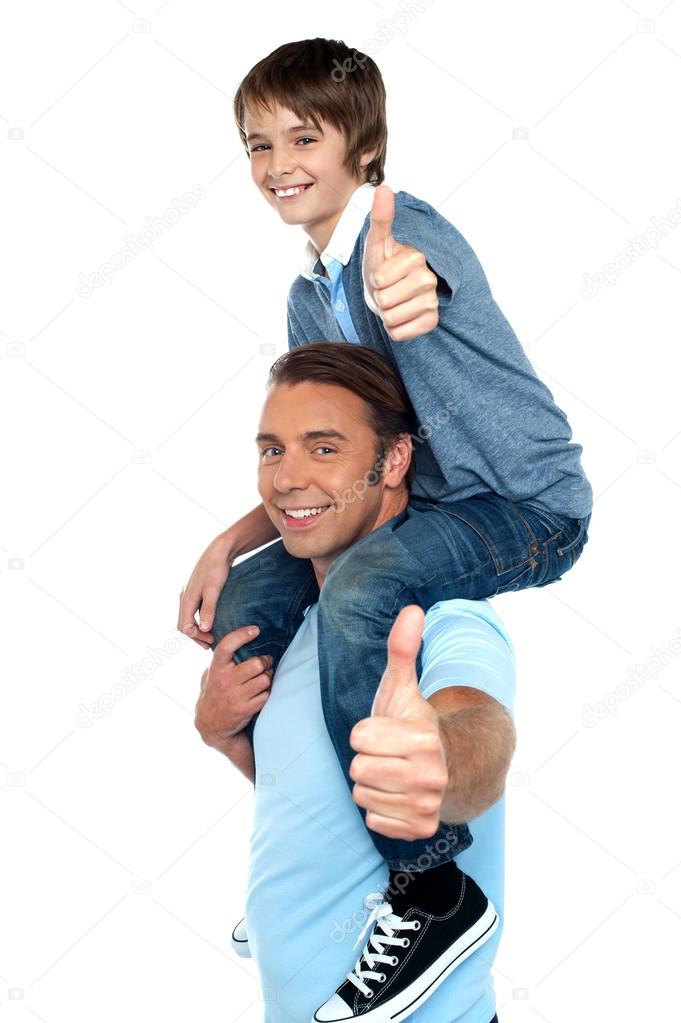 Confident father carrying his son on shoulder