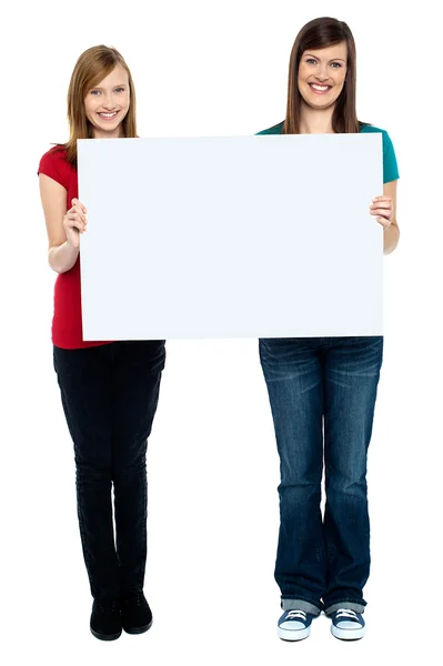 Pair of good looking women holding whiteboard — Stock Photo, Image