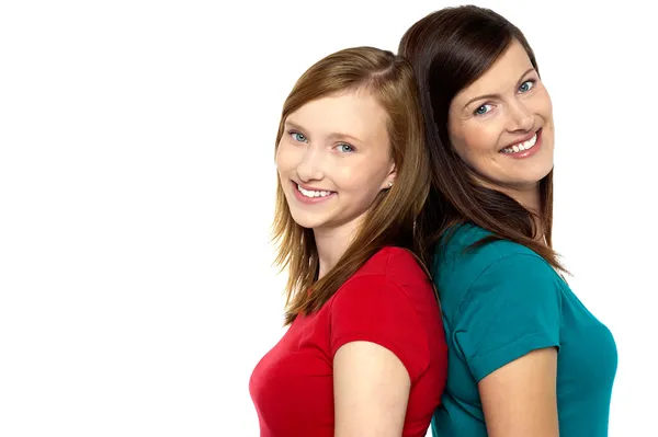 Joyous trendy mom and daughter standing back to back — Stock Photo, Image